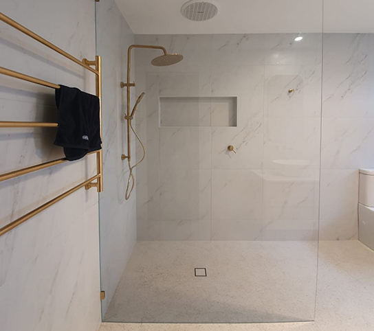 Frameless glass showerscreen with gold hardware